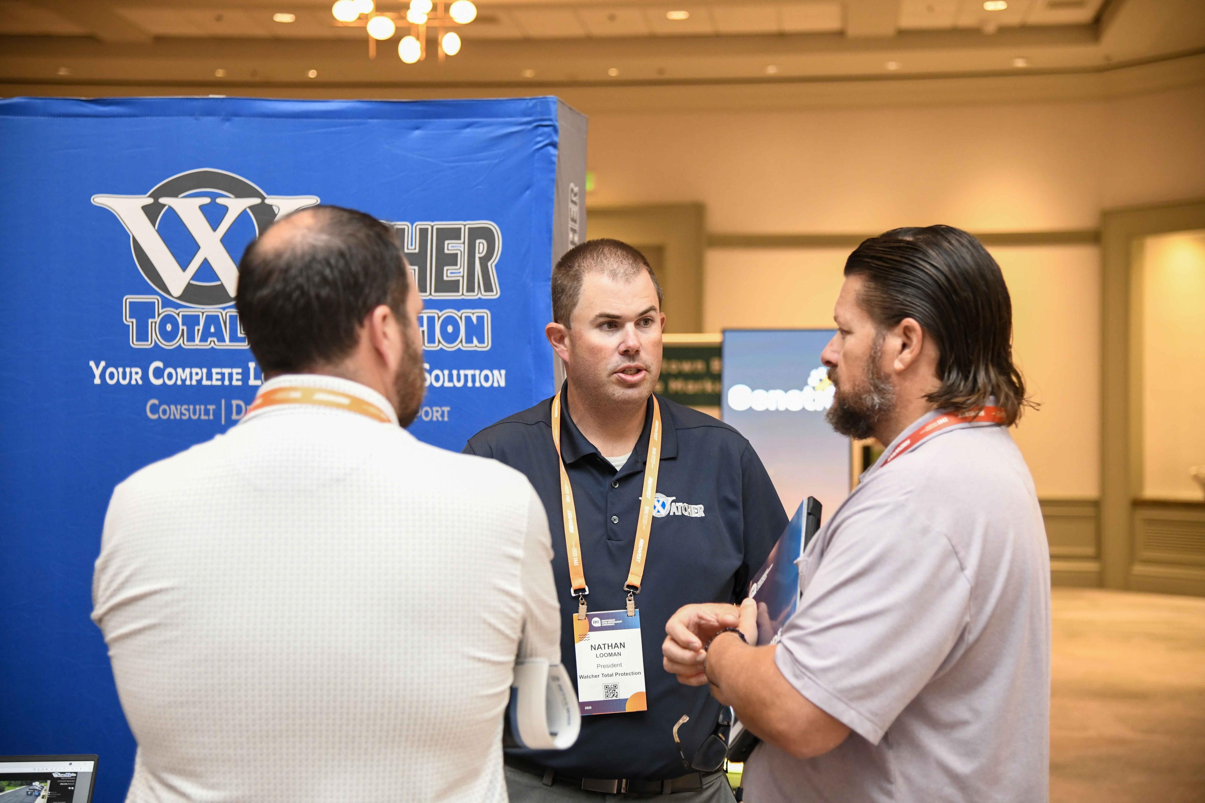 Watcher Total Protection speaks with retailers in their booth.